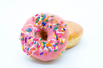 Standing pink donut with colorful sprinkles on a white background