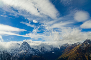 Obraz premium Clouds and snowy peaks of the mountains