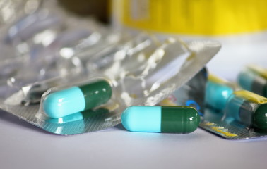 green-blue antibiotic capsule pills in blister pack