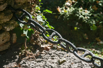 Thick iron black chain links fence closeup as a decorative element in park garden - Powered by Adobe