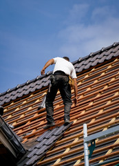 Dachdecker bewegt sich sicher auf ein Dach eines Neubaues