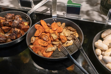 Grilled Eryngi mushroom and carrot in fry pan. Detail of buffet served in line