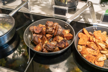 Roasted potato in fry pan. Detail of buffet served in line at hotel