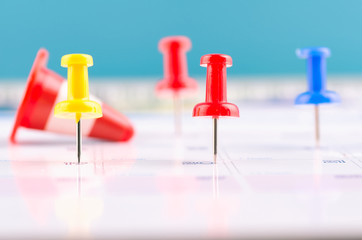 close up of colorful pin on calendar for business appointment or planning concept