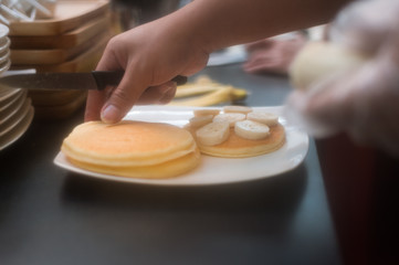 three pancakes with banana in white dish. vintage concept