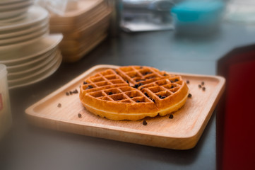 waffles with chocolate sauce on wooden plate. vintage concept