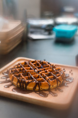 waffles with chocolate sauce on wooden plate. vintage concept