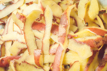 Purified skin of fresh potatoes with special knife on sink.