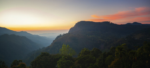 Majestic sunset in the mountains landscape with sunny beams. Dramatic scene. Sri Lanka Ella rock