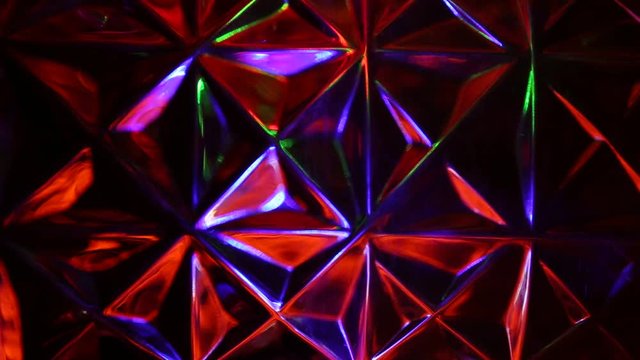 Multicolored lights flicker on the background of the triangles