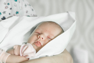 Sleeping newborn baby closeup portrait in mother's hands
