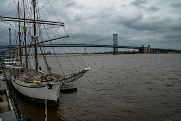 Fototapeta na wymiar Sailboat in Philadelphia with Benjamin Franklin Bridge in Background