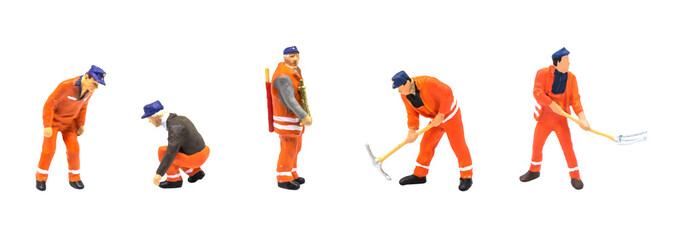 Miniature figurine character as construction worker standing and working in posture isolated on white background.