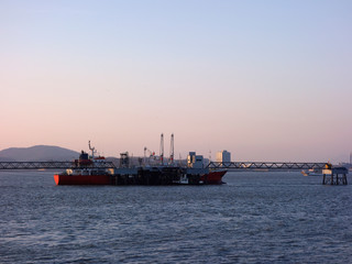 Incheon coastline, South Korea, under the background of sunset and blue sky, with ships sailing, city horizon.