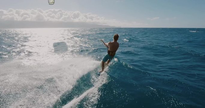 Young athletic man kitesurfing POV follow cam, extreme action sports POV, tropical island surf adventure