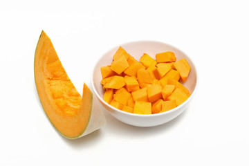 Pumpkin sliced in a white plate on a white background.