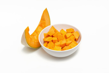 Pumpkin sliced in a white plate on a white background.