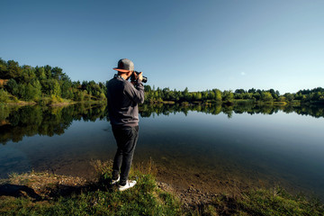 Obraz premium Young man taking pictures of a lake