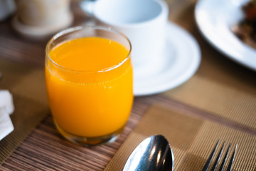 Glass of orange juice on table in restaurant for breakfast.