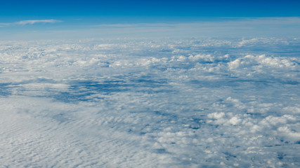 The beautiful cloudscape with clear blue sky. A view from airplane window.