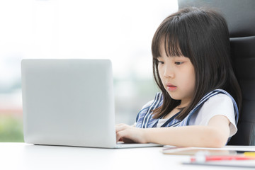 Asian girl uses laptop and smile to camera..