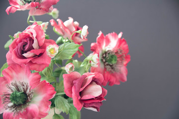 beautiful artificial flowers on grey background. Art soft focus
