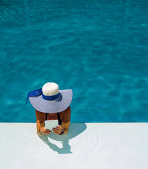 Fototapeta na wymiar Woman at the swimming pool reading