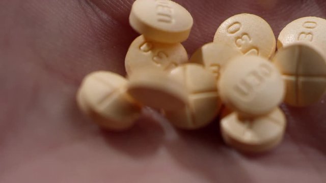 Macro close-up of amphetamine / dextroamphetamine pills in a human hand