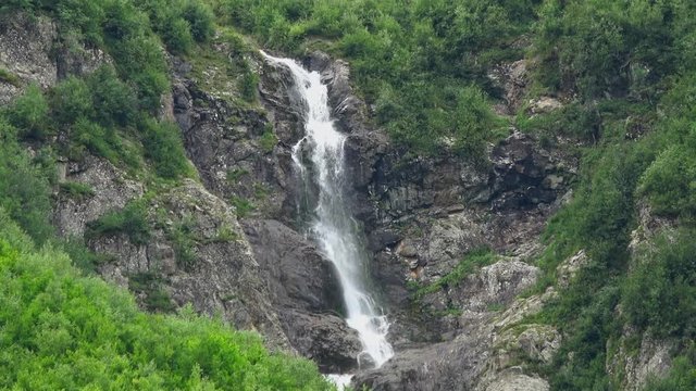 View waterfall scenes in mountains, national park Dombai, Caucasus, Russia. Summer landscape, sunshine weather and sunny day