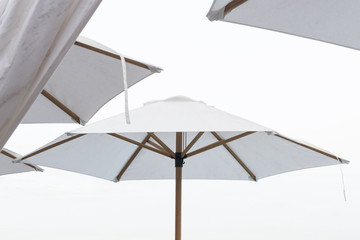 Summer day at the beach with white umbrellas.