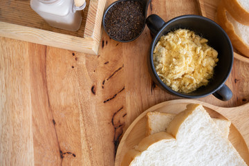 Dried shredded pork in black bowl with slices bread on wooden table.