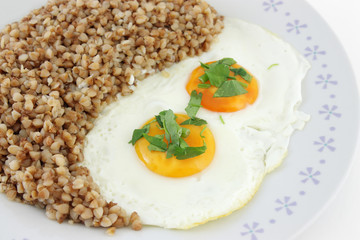 Fried Eggs with buckwheat porridge in plate