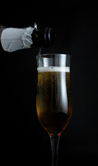 champagne pouring into glass on black background