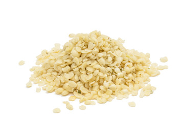 Pile or heap of shelled hemp seeds seen obliquely from above and isolated on white background 