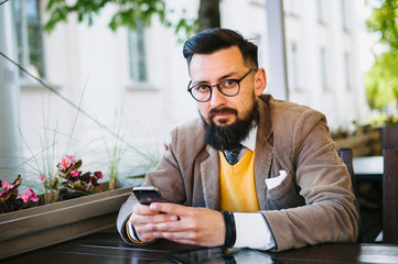 young bearded man is sitting in a cafe