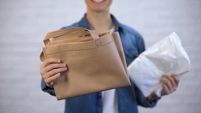 Girl choosing trendy ecobag instead plastic package, pollution with polyethylene