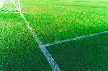 Green soccer field, White lines and green lawn, The football field corner with artificial grass.