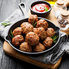 Meatballs served with tomato sauce in frying pan .