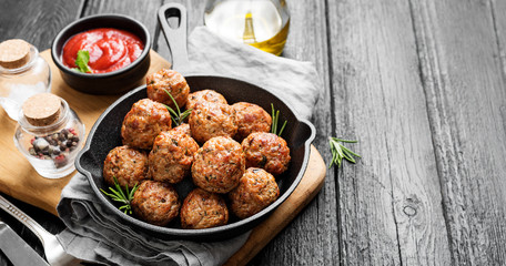 Meatballs served with tomato sauce in frying pan .