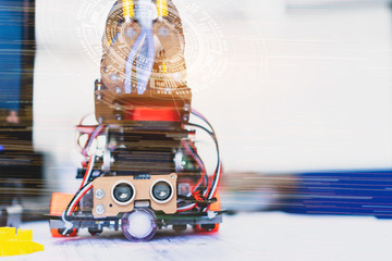 Robotics technology and STEM education class concept :  Metal robot and electronic board robots with HUD futuristic graphic, Programs for learning coding study in computer laboratory in school for kid