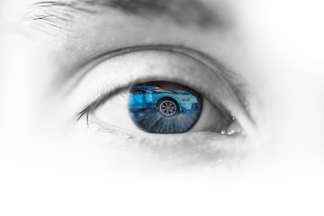 female eye with a reflection of the car inside the eye, driving and travel abstraction