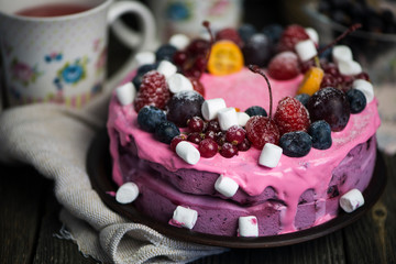 yogurt cake with fruit and marshmallows on a wooden background