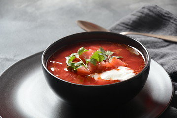 Traditional Ukrainian Russian borsch. Bowl of red beet root soup borsch with white cream on dark background. Beet Root delicious soup . Traditional Ukrainian food cuisine