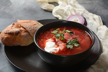 Traditional Ukrainian Russian borsch. Bowl of red beet root soup borsch with white cream on dark background. Beet Root delicious soup . Traditional Ukrainian food cuisine