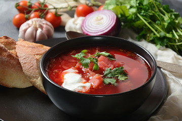 Traditional Ukrainian Russian borsch. Bowl of red beet root soup borsch with white cream on dark background. Beet Root delicious soup . Traditional Ukrainian food cuisine