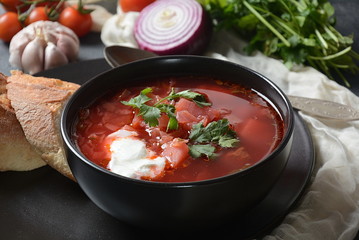 Traditional Ukrainian Russian borsch. Bowl of red beet root soup borsch with white cream on dark background. Beet Root delicious soup . Traditional Ukrainian food cuisine