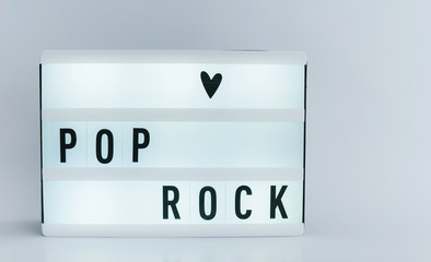 Photo of a light box with text, POP ROCK, over white background isolated