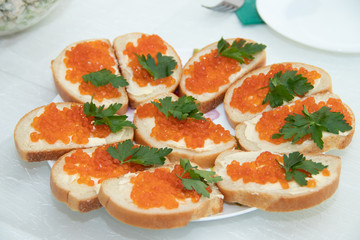 Sandwiches with caviar. Red caviar. Food on the holiday table. Snacks on a plate.