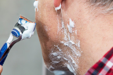 Fototapeta premium man shaving his beard in bathroom