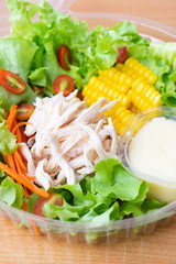 Rip chicken salad with corn,green oak, onion and tomato in clean plastic box.